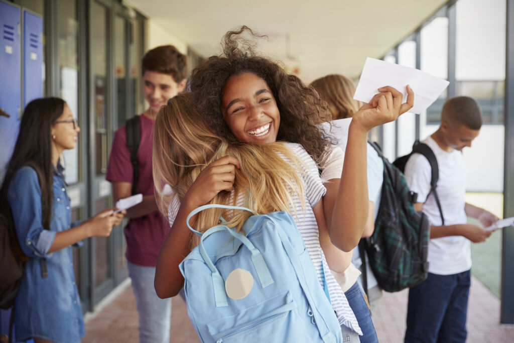 dos ninas celebrar examen resultados escuela pasillo