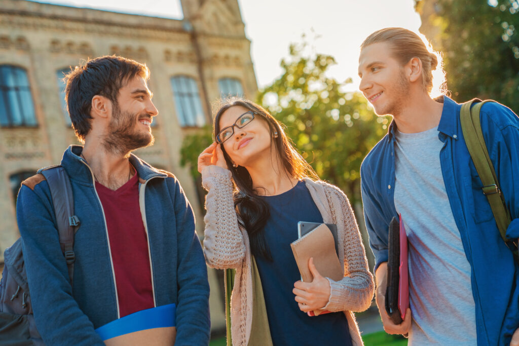 grupo estudiantes diversos afuera sonriendo hablando juntos cerca universidad