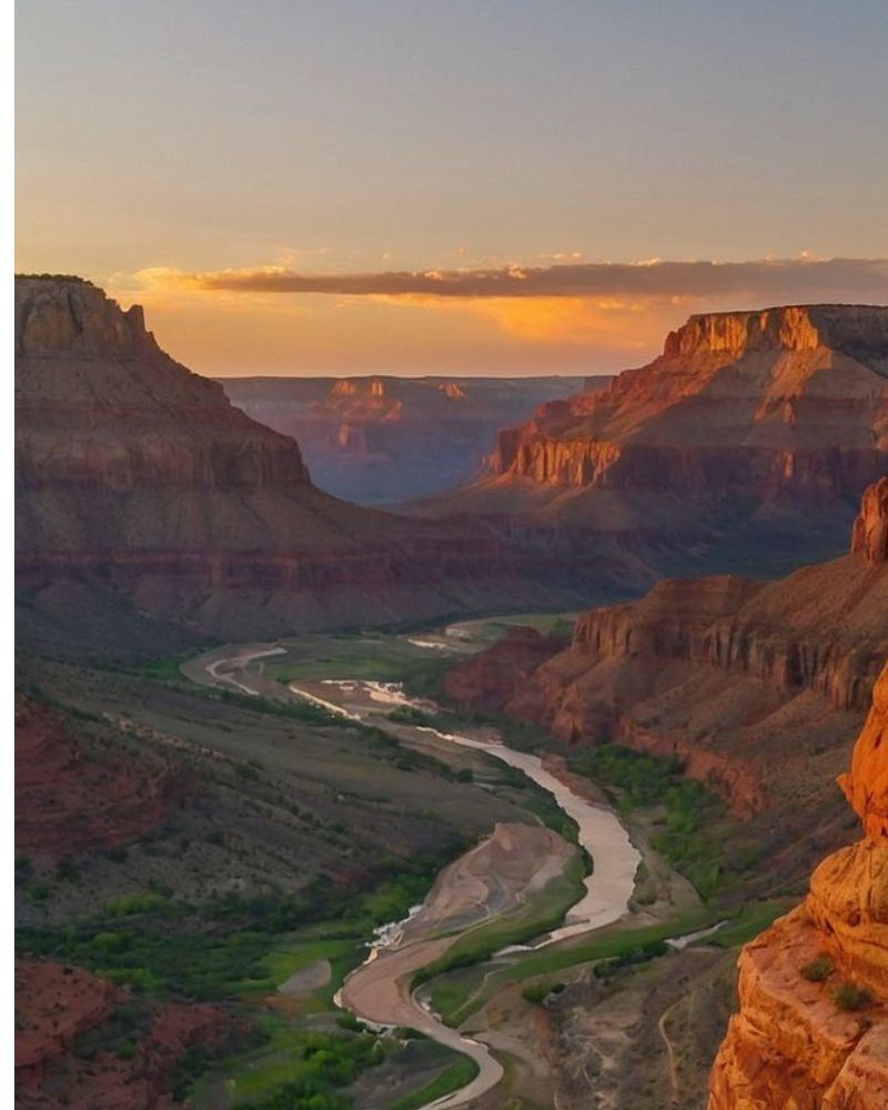 Fotografía de una vista profunda y panorámica del Gran Cañón en Estados Unidos durante el atardecer. La luz cálida y dorada ilumina las capas de roca mientras el río Colorado serpentea por el fondo del cañón bajo un cielo con nubes coloridas. Un destino imprescindible para viajar por EE. UU.